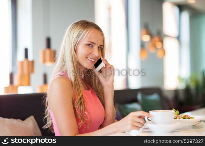 people, communication and leisure concept - happy woman drinking coffee at restaurant and calling on smartphone. woman with coffee calling smartphone at restaurant