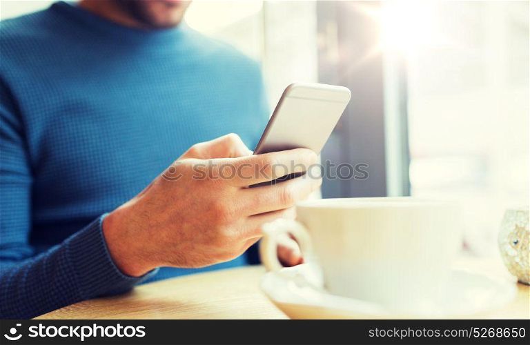 people, communication and technology concept - close up of man with smartphones at cafe. close up of man with smartphones at cafe