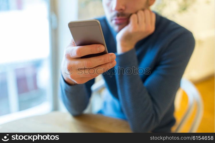 people, communication and technology concept - close up of man with smartphones at cafe