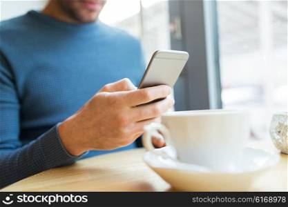 people, communication and technology concept - close up of man with smartphones at cafe