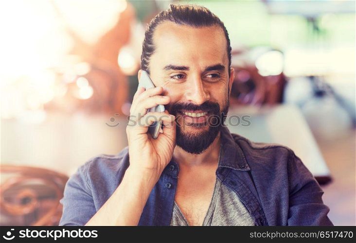 people, communication and technology concept - happy man calling on smartphone at bar or pub. happy man calling on smartphone at bar or pub. happy man calling on smartphone at bar or pub