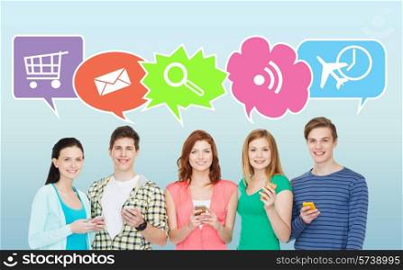 people, communication and technology concept - smiling friends showing blank smartphones screens over blue background with doodles