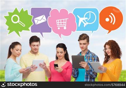 people, communication and technology concept - smiling friends with smartphones and tablet pc computers over blue sky and grass background with doodles