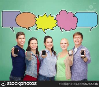 people, communication, school, advertisement and technology concept - smiling friends showing blank smartphones screens over blue background with doodles