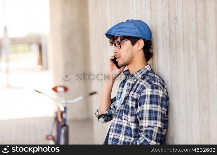 people, communication, technology and lifestyle - hipster man calling on smartphone and fixed gear bike on city street