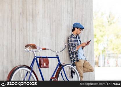 people, communication, technology and lifestyle - hipster man with smartphone, earphones and fixed gear bike listening to music on city street