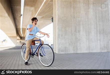 people, communication, technology, leisure and lifestyle - hipster man texting on smartphone with fixed gear bicycle on city street