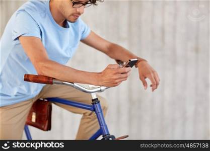 people, communication, technology, leisure and lifestyle - hipster man texting on smartphone with fixed gear bike on street
