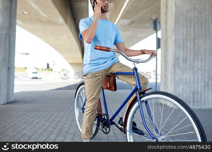 people, communication, technology, leisure and lifestyle - hipster man with fixed gear bike calling on smartphone on street