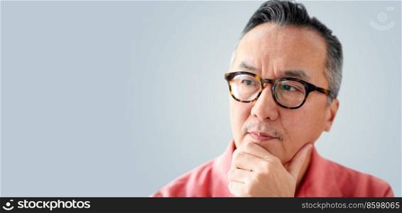 people concept - close up of asian man thinking on grey background. close up of asian man thinking on grey background