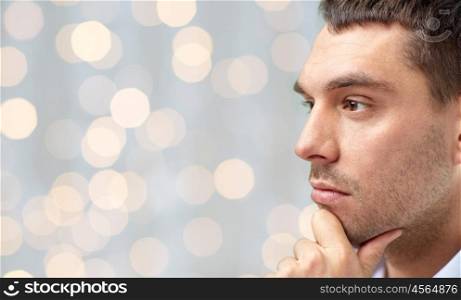 people concept - close up of male face over holidays lights background. close up of male face over lights background