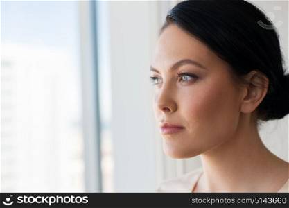 people concept - close up of woman looking through window. close up of woman looking through window