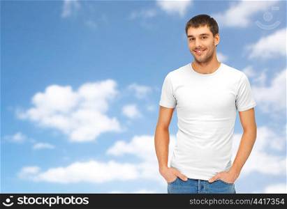 people concept - handsome man in blank white t-shirt over blue sky and clouds background. happy man in blank white t-shirt