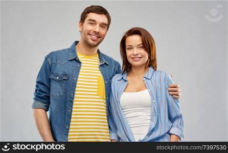 people concept - happy couple hugging over grey background. happy couple hugging over grey background