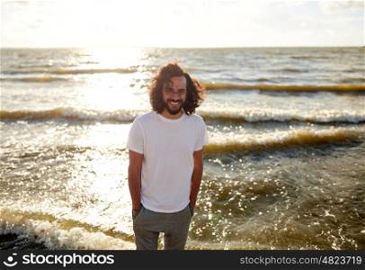 people concept - happy smiling man in white t-shirt on beach over sea. happy man in white t-shirt on beach over sea