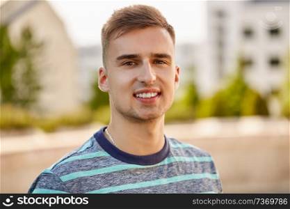 people concept - portrait of young man outdoors in summer city. portrait of young man in summer city