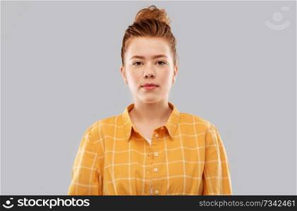 people concept - red haired teenage girl in checkered shirt over grey background. red haired teenage girl in checkered shirt