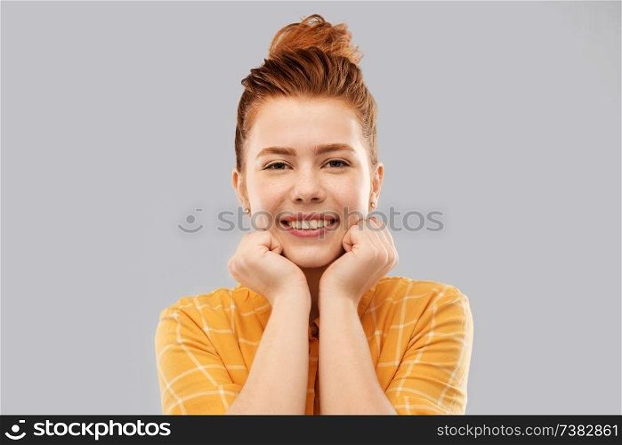 people concept - smiling red haired teenage girl in checkered shirt over grey background. smiling red haired teenage girl in checkered shirt