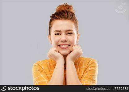 people concept - smiling red haired teenage girl in checkered shirt over grey background. smiling red haired teenage girl in checkered shirt