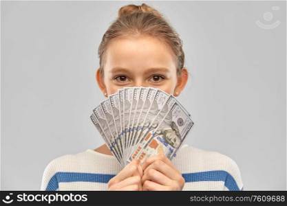 people concept - smiling teenage girl in pullover holding hundreds of dollar money banknotes over grey background. smiling teenage girl with dollar money banknotes