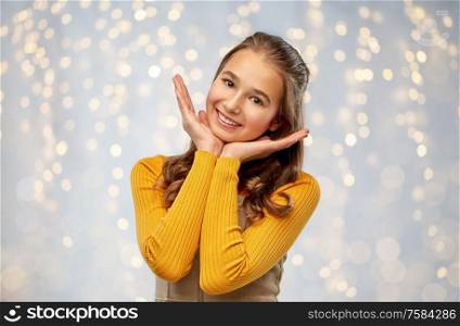 people concept - smiling teenage girl over festive lights background. smiling teenage girl over grey background