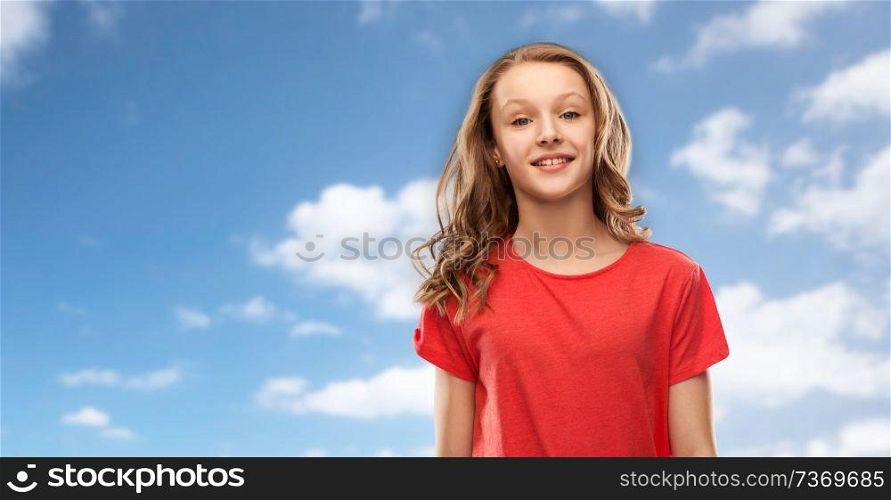 people concept - smiling teenage girl with long hair in red t-shirt over blue sky and clouds background. smiling teenage girl in red t-shirt over sky