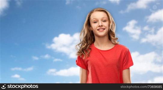 people concept - smiling teenage girl with long hair in red t-shirt over blue sky and clouds background. smiling teenage girl in red t-shirt over sky
