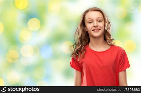 people concept - smiling teenage girl with long hair in red t-shirt over summer green lights background. teenage girl in red t-shirt over green lights