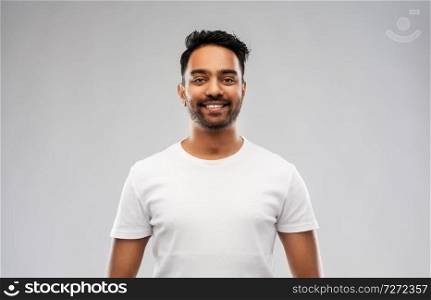 people concept - smiling young indian man over gray background. smiling young indian man over gray background