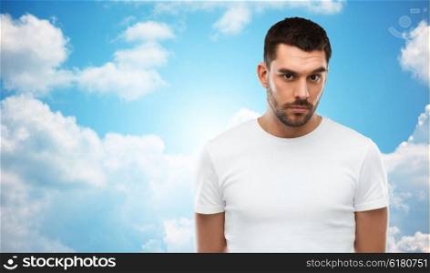 people concept - young man portrait over blue sky and clouds background. young man portrait over sky and clouds background