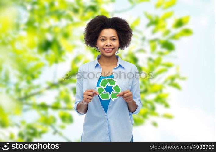 people, conservation, ecology and environment concept - happy afro american young woman with recycling symbol over summer natural background. happy afro american woman over natural background