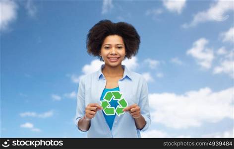people, conservation, ecology and environment concept - happy afro american young woman with recycling symbol over blue sky background. happy afro american woman over blue sky
