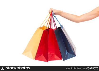 people, consumerism and sale concept - close up of female hand holding shopping bags