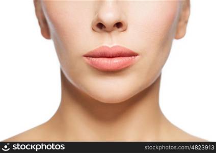 people, cosmetology, plastic surgery, anti-aging and beauty concept - closeup of beautiful young woman face and lips over white background
