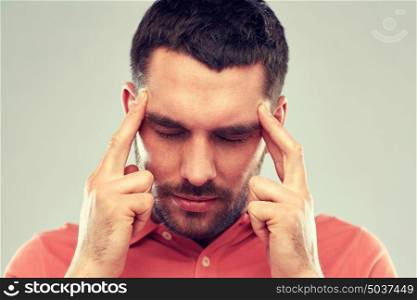 people, crisis, emotions and stress concept - man suffering from head ache or thinking over gray background. man suffering from head ache or thinking