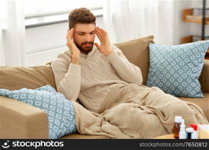 people, crisis, emotions and stress concept - unhappy man suffering from head ache at home. unhappy man suffering from head ache at home