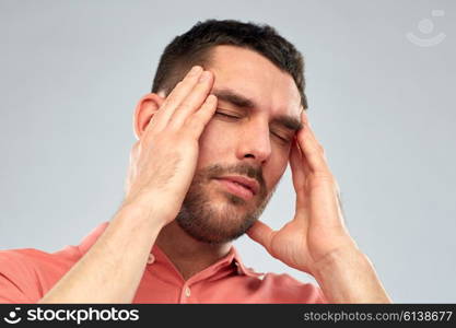 people, crisis, emotions and stress concept - unhappy man suffering from head ache over gray background