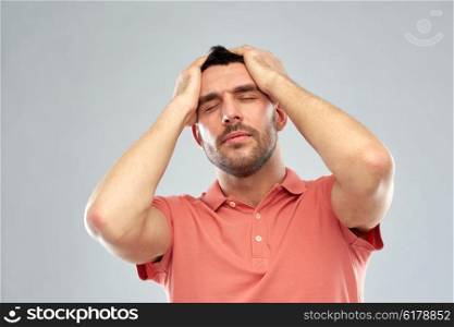 people, crisis, emotions and stress concept - unhappy man suffering from head ache over gray background