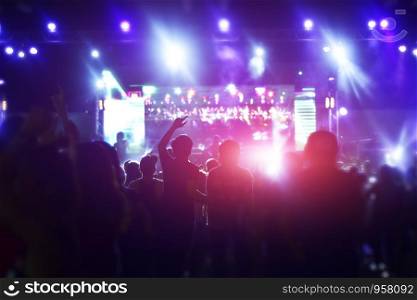people dancing and holding hand up in party concert