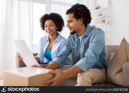 people, delivery and consumerism concept - happy couple with parcel box and paper form home. happy couple with parcel box and paper form home