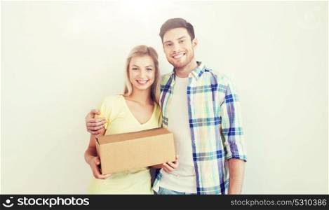 people, delivery, mail, shipping and moving concept - smiling couple with cardboard box. smiling couple with box moving to new home