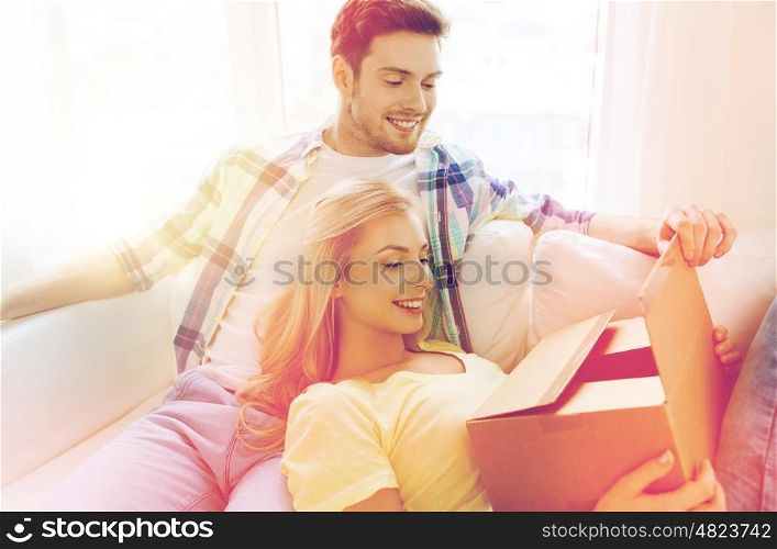 people, delivery, mail, shipping and moving concept - smiling couple with cardboard box at home