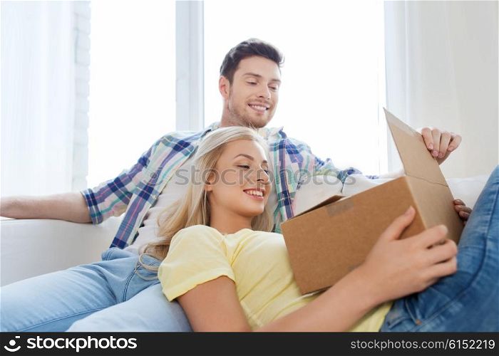 people, delivery, mail, shipping and moving concept - smiling couple with cardboard box at home