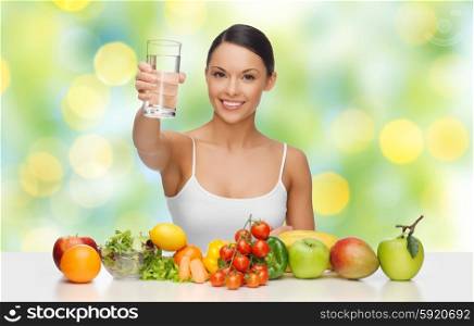 people, diet and vegetarian concept - happy asian woman with healthy food showing glass of water over green lights background