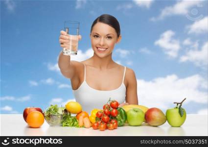 people, diet, healthy eating and food concept - happy woman with glass of water, fruits and vegetables over blue sky and clouds background. happy woman with glass of water and healthy food