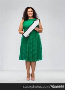 people, direction and communication concept - happy woman in green dress holding big white thick arrow showing to north east over grey background. happy woman with arrow showing north east