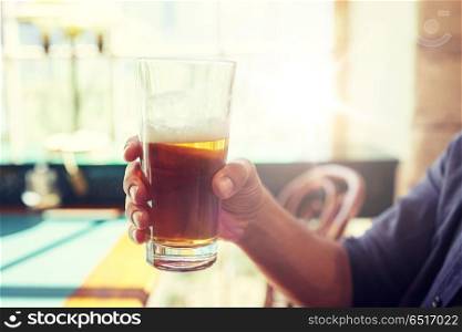 people, drinks, alcohol and leisure concept - close up of man drinking beer from glass at bar or pub. close up of man drinking beer at bar or pub. close up of man drinking beer at bar or pub