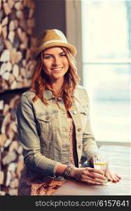 people, drinks, alcohol and leisure concept - happy young redhead woman drinking water at bar or pub