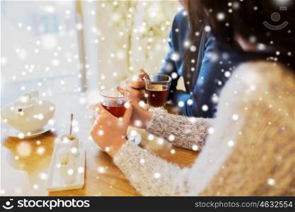 people, drinks and dating concept - close up of couple drinking tea at cafe