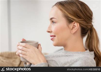 people, drinks and leisure concept - happy woman with cup of tea or coffee drinking at home. happy woman with cup or mug drinking at home
